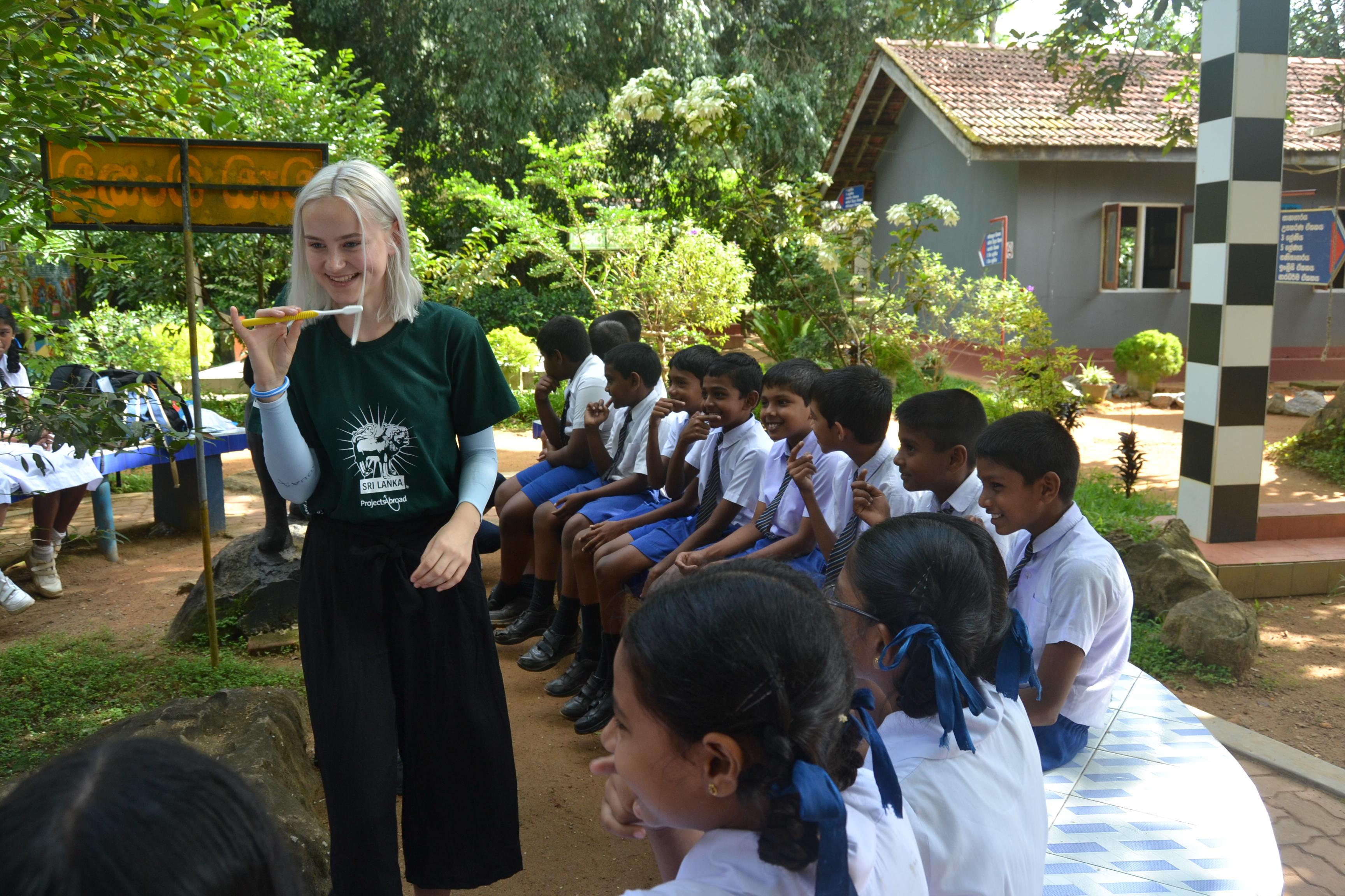 A female intern teaches a group of children how to correctly brush their teeth whilst on her public health internship in Sri Lanka with Projects Abroad. Female Projects Abroad intern can be seen teaching a group of children how to correctly brush their teeth whilst on her public health internship in Sri Lanka.
